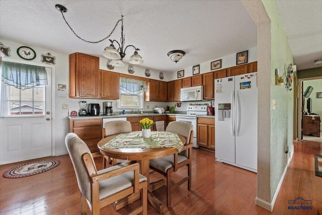 720 S 32nd, Spearfish, SD 57783 - kitchen with white appliances, a textured ceiling, wood finished floors, and brown cabinets