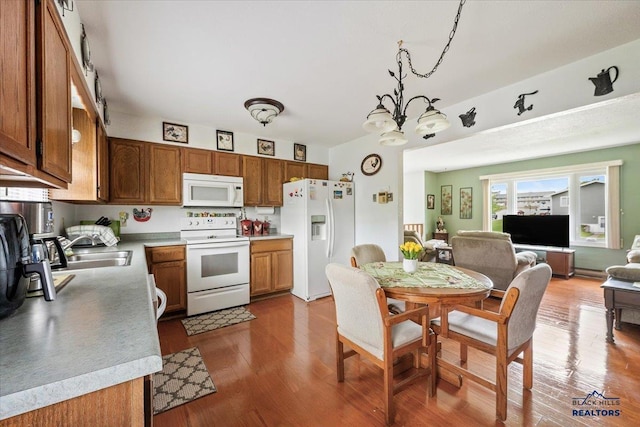 720 S 32nd, Spearfish, SD 57783 - kitchen with white appliances, brown cabinetry, a chandelier, and a sink