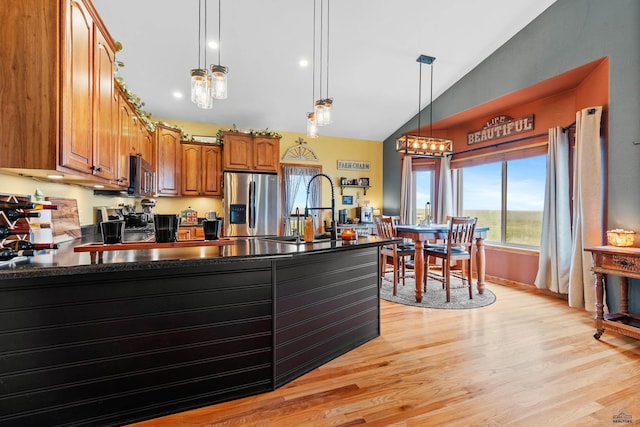 22841 Gateway Dr, Box Elder, SD 57719 - kitchen with appliances with stainless steel finishes, dark countertops, a peninsula, lofted ceiling, and brown cabinets