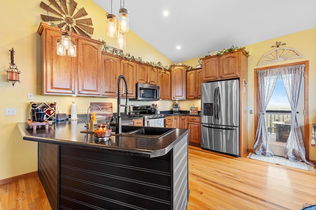 22841 Gateway Dr, Box Elder, SD 57719 - kitchen with stainless steel appliances, a peninsula, dark countertops, light wood-style flooring, and brown cabinetry