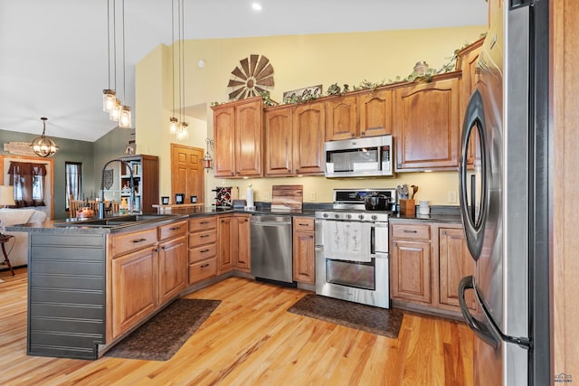 22841 Gateway Dr, Box Elder, SD 57719 - kitchen featuring appliances with stainless steel finishes, a sink, dark countertops, a peninsula, and light wood finished floors