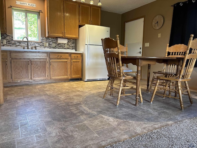 1523 Hope St, Sturgis, SD 57785 - kitchen with freestanding refrigerator, a sink, tasteful backsplash, and light countertops
