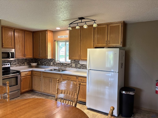 1523 Hope St, Sturgis, SD 57785 - kitchen featuring stainless steel appliances, a sink, backsplash, a textured ceiling, and light countertops