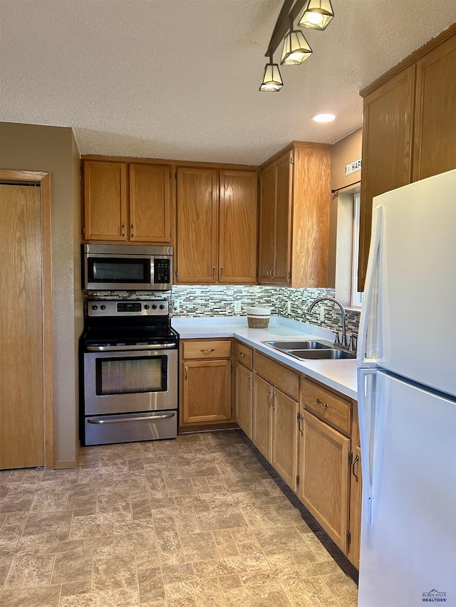 1523 Hope St, Sturgis, SD 57785 - kitchen featuring stainless steel appliances, a sink, light countertops, backsplash, and a textured ceiling