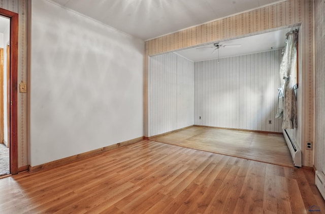 12384 Stannum Pl, Hill City, SD 57745 - unfurnished room with wallpapered walls, light wood-style flooring, a ceiling fan, a baseboard radiator, and baseboards
