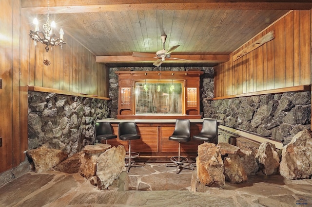 12384 Stannum Pl, Hill City, SD 57745 - living area featuring wooden ceiling, stone floors, wood walls, ceiling fan, and a bar