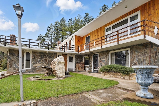 12384 Stannum Pl, Hill City, SD 57745 - rear view of property with stone siding, a balcony, and a lawn