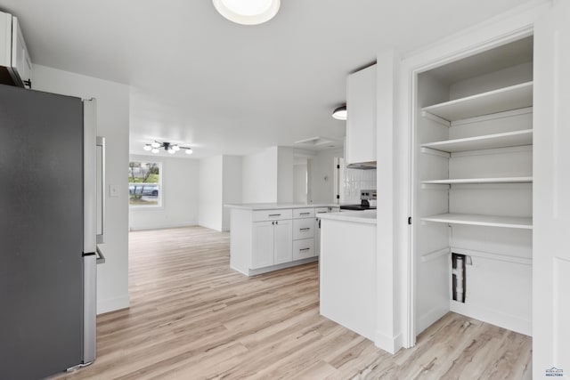 726 Willsie Ave, Rapid City, SD 57701 - kitchen with appliances with stainless steel finishes, light wood-style floors, white cabinets, light countertops, and a peninsula