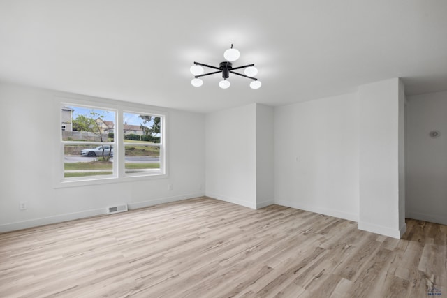 726 Willsie Ave, Rapid City, SD 57701 - unfurnished room featuring a chandelier, light wood-style flooring, and baseboards