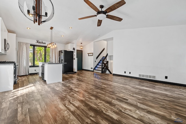 1215 Range View Cir, Rapid City, SD 57701 - unfurnished living room with vaulted ceiling, dark wood-style flooring, ceiling fan, stairway, and a chandelier