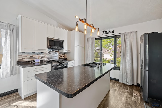 1215 Range View Cir, Rapid City, SD 57701 - kitchen featuring appliances with stainless steel finishes, a sink, vaulted ceiling, decorative backsplash, and wood finished floors