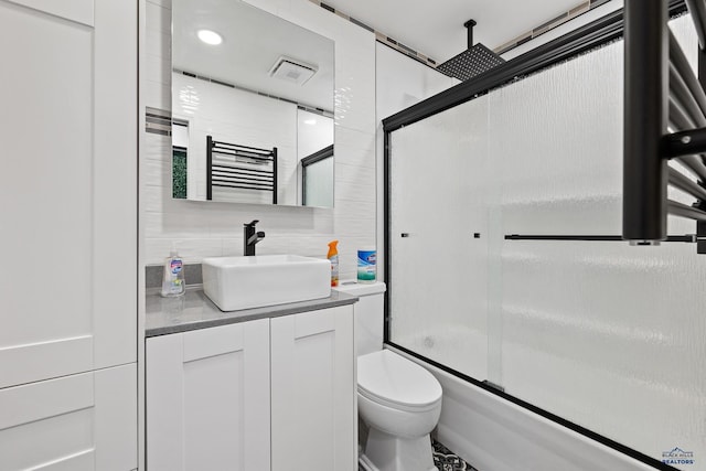 1215 Range View Cir, Rapid City, SD 57701 - bathroom featuring vanity, a towel warming rack, toilet, a combined bath / shower with rainfall shower, and tasteful backsplash
