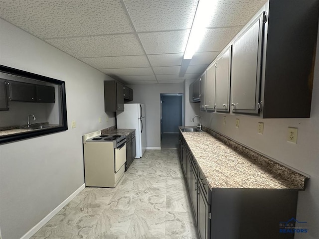 414 2nd Ave, Edgemont, SD 57735 - kitchen featuring electric range oven, a sink, a paneled ceiling, freestanding refrigerator, and baseboards