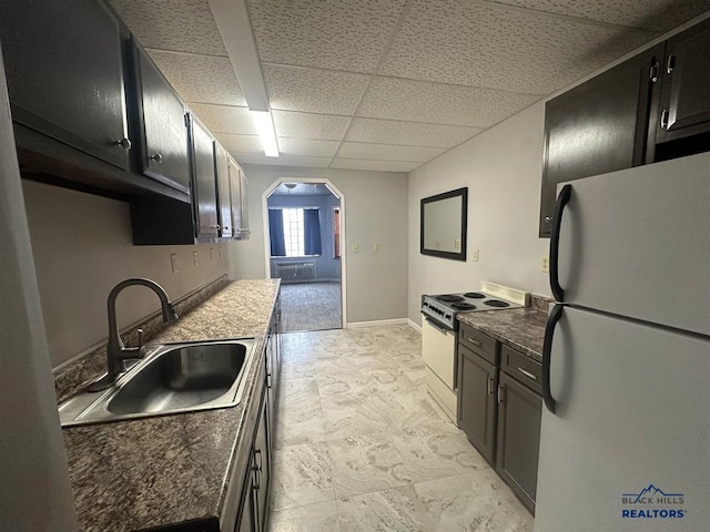 414 2nd Ave, Edgemont, SD 57735 - kitchen featuring white appliances, a sink, arched walkways, a paneled ceiling, and dark cabinetry