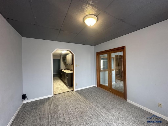 414 2nd Ave, Edgemont, SD 57735 - carpeted spare room featuring arched walkways, baseboards, a drop ceiling, a sink, and french doors