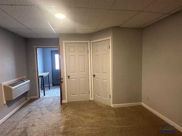 414 2nd Ave, Edgemont, SD 57735 - carpeted empty room with a paneled ceiling, an AC wall unit, and baseboards