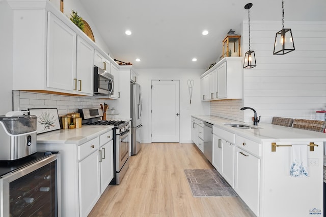 4553 Lahinch St, Rapid, SD 57702 - kitchen featuring stainless steel appliances, a sink, wine cooler, light wood-style floors, and decorative backsplash
