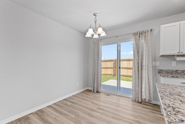 416 Henry Potter Rd, Box Elder, SD 57719 - unfurnished dining area with a chandelier, baseboards, and light wood-type flooring
