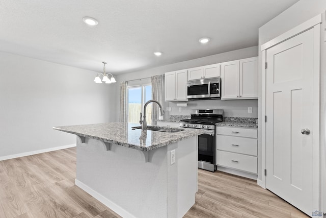416 Henry Potter Rd, Box Elder, SD 57719 - kitchen with stainless steel appliances, a sink, a chandelier, white cabinetry, and light stone counters