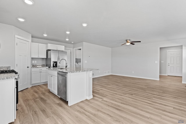 416 Henry Potter Rd, Box Elder, SD 57719 - kitchen with appliances with stainless steel finishes, a ceiling fan, light wood finished floors, white cabinetry, and an island with sink