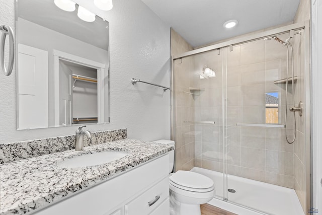 416 Henry Potter Rd, Box Elder, SD 57719 - full bath with vanity, a shower stall, toilet, a textured wall, and recessed lighting