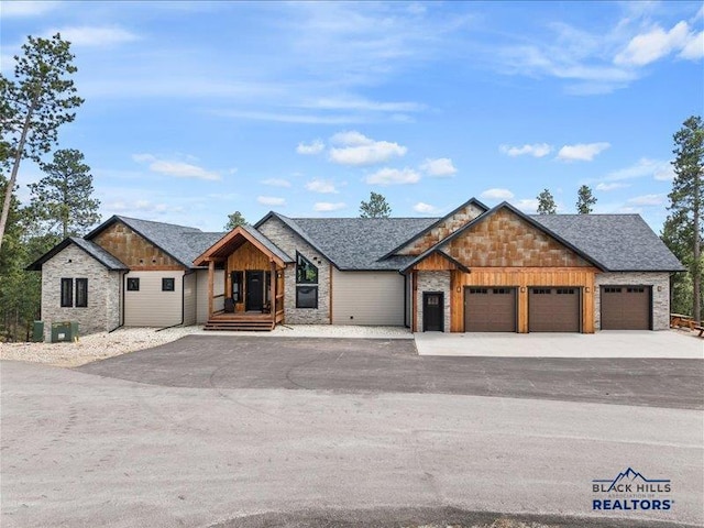 11311 Overlook Ct, Lead, SD 57754 - view of front of home featuring an attached garage, driveway, stone siding, and a shingled roof