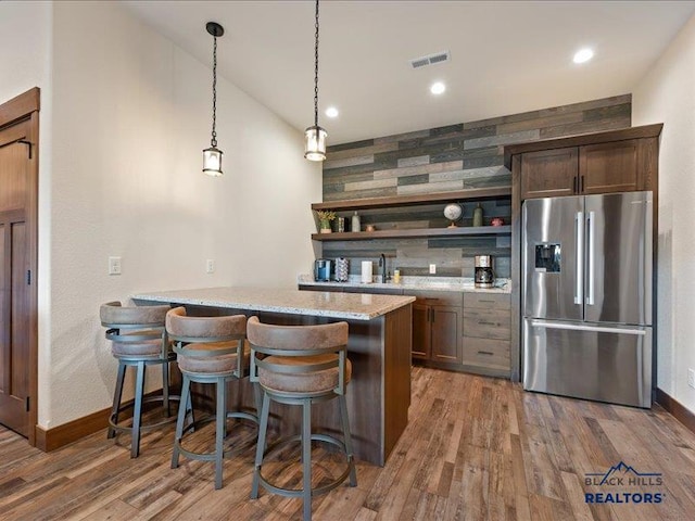 11311 Overlook Ct, Lead, SD 57754 - indoor wet bar featuring stainless steel fridge with ice dispenser, baseboards, wood finished floors, recessed lighting, and vaulted ceiling