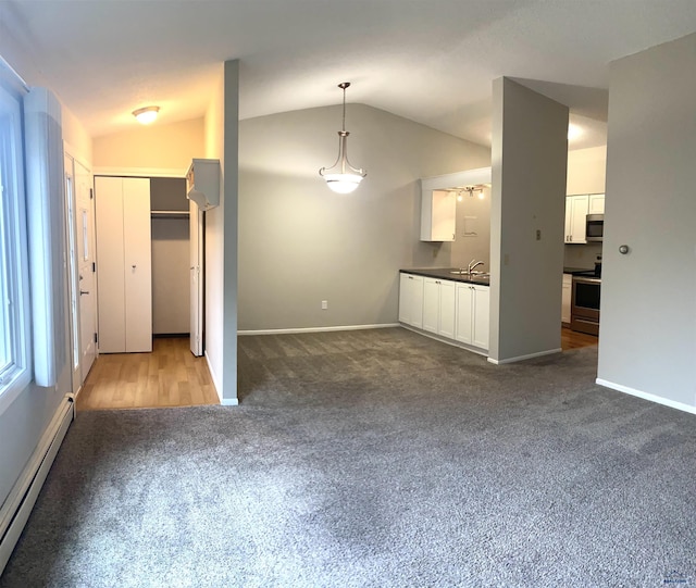 305 S Canyon Rd Unit 8D, Rapid City, SD 57702 - unfurnished living room featuring a baseboard radiator, dark colored carpet, vaulted ceiling, a sink, and baseboards