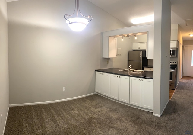 305 S Canyon Rd Unit 8D, Rapid City, SD 57702 - kitchen with stainless steel appliances, dark countertops, dark colored carpet, white cabinets, and a sink