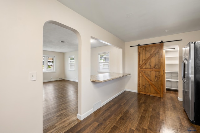 814 Flormann, Rapid City, SD 57701 - kitchen featuring freestanding refrigerator, dark wood-style flooring, a barn door, and plenty of natural light