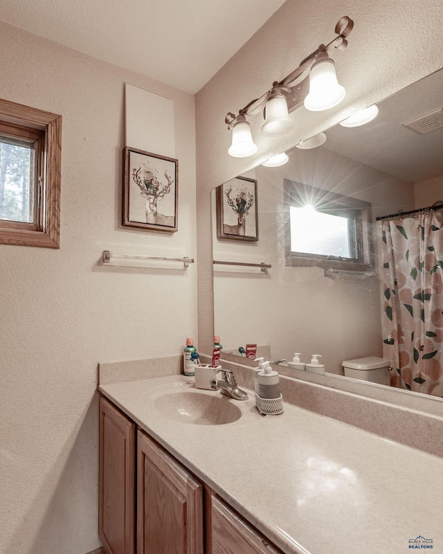 7410 Pinewood Ct, Rapid City, SD 57702 - full bathroom featuring vanity, toilet, a shower with curtain, and a textured wall