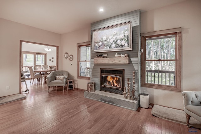 7410 Pinewood Ct, Rapid City, SD 57702 - living room with wood finished floors, a glass covered fireplace, healthy amount of natural light, and recessed lighting