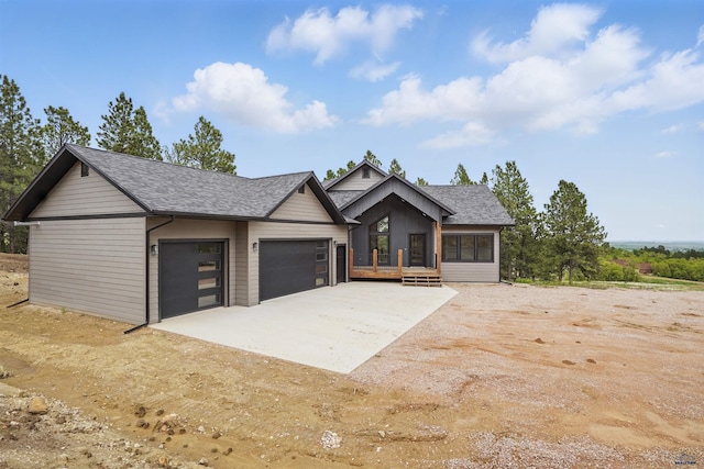 12290 Prairie View Loop, Whitewood, SD 57793 - view of front facade with roof with shingles, a garage, and dirt driveway