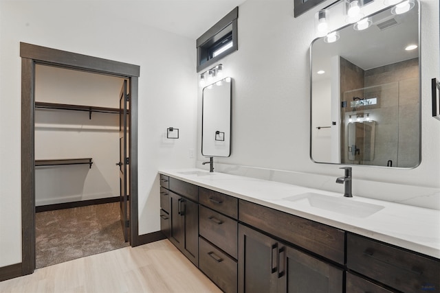 12290 Prairie View Loop, Whitewood, SD 57793 - bathroom with double vanity, a shower stall, a walk in closet, and baseboards