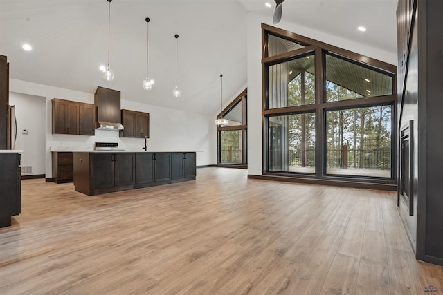 12290 Prairie View Loop, Whitewood, SD 57793 - kitchen featuring high vaulted ceiling, open floor plan, light wood-style flooring, dark brown cabinets, and baseboards