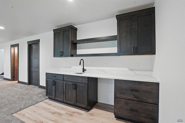 12290 Prairie View Loop, Whitewood, SD 57793 - kitchen featuring open shelves, a sink, light wood-type flooring, and light stone countertops
