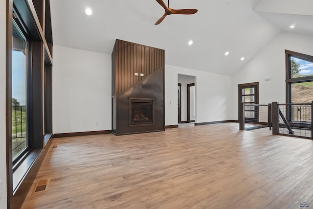 12290 Prairie View Loop, Whitewood, SD 57793 - unfurnished living room featuring high vaulted ceiling, a ceiling fan, light wood-style floors, baseboards, and a fireplace