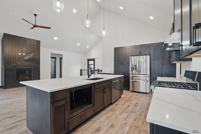 12290 Prairie View Loop, Whitewood, SD 57793 - kitchen with appliances with stainless steel finishes, exhaust hood, high vaulted ceiling, ceiling fan, and a center island with sink