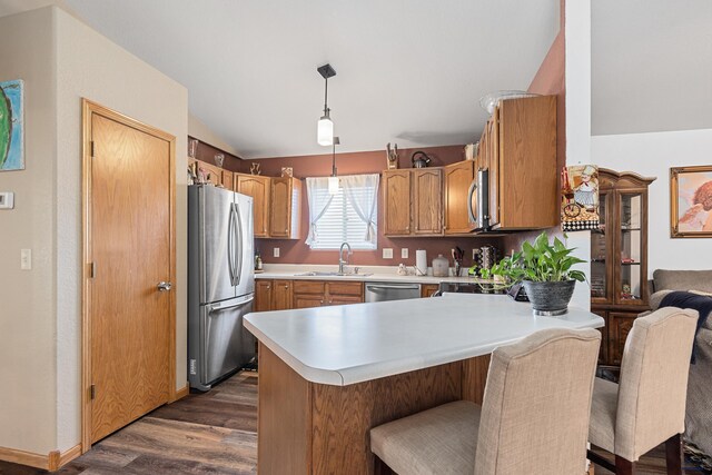 2503 Shad, Rapid City, SD 57703 - kitchen with appliances with stainless steel finishes, vaulted ceiling, a sink, dark wood-style floors, and light countertops