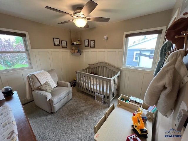 2104 Colorado, Sturgis, SD 57785 - bedroom with a wainscoted wall, a crib, a decorative wall, and ceiling fan