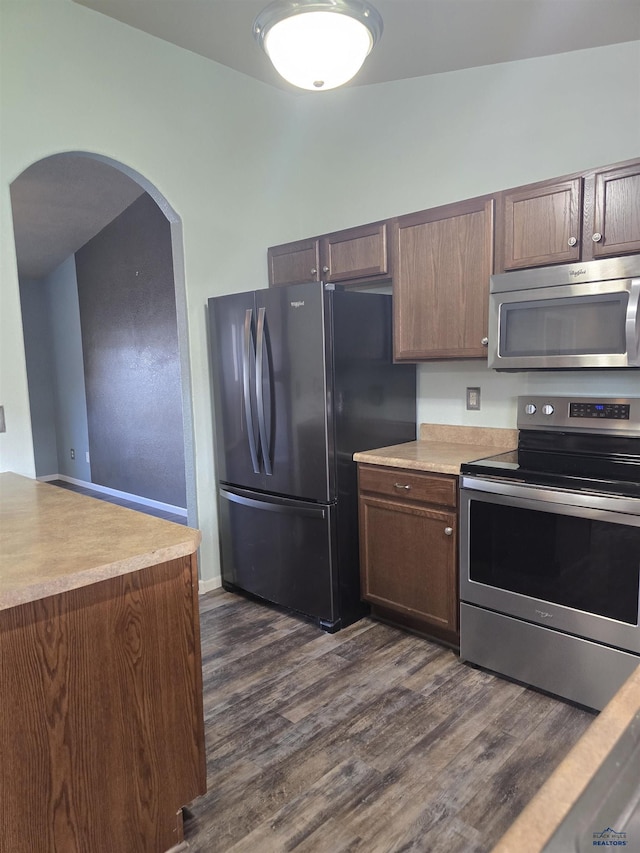 14655 Telluride St, Summerset, SD 57769 - kitchen with appliances with stainless steel finishes, arched walkways, dark wood-style floors, and light countertops