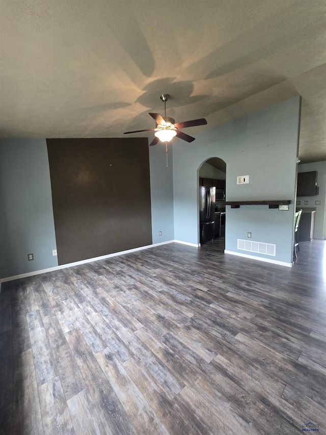 14655 Telluride St, Summerset, SD 57769 - unfurnished living room featuring arched walkways, a ceiling fan, dark wood-type flooring, and baseboards