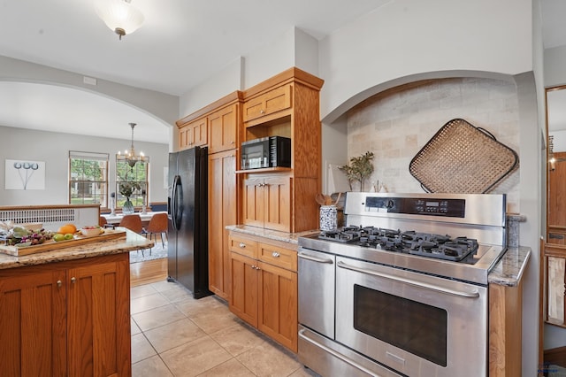 902 Fulton St, Rapid City, SD 57701 - kitchen with double oven range, black refrigerator with ice dispenser, a chandelier, and light stone countertops