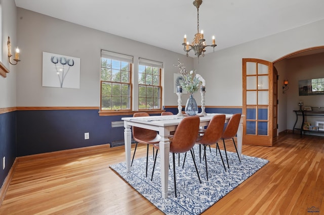 902 Fulton St, Rapid City, SD 57701 - dining area with a chandelier, arched walkways, light wood-style floors, and baseboards