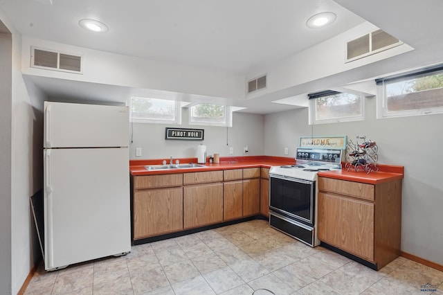 902 Fulton St, Rapid City, SD 57701 - kitchen with white appliances, a sink, healthy amount of natural light, brown cabinets, and recessed lighting