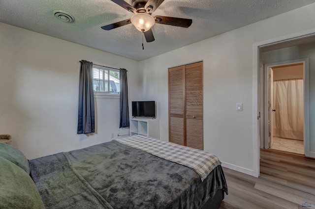426 E Oakland, Rapid City, SD 57701 - bedroom featuring wood finished floors, a closet, a textured ceiling, baseboards, and ceiling fan