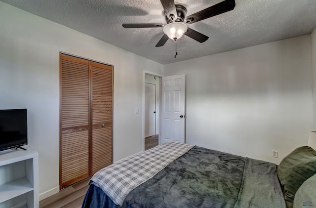 426 E Oakland, Rapid City, SD 57701 - bedroom featuring wood finished floors, a textured ceiling, a closet, a ceiling fan, and baseboards