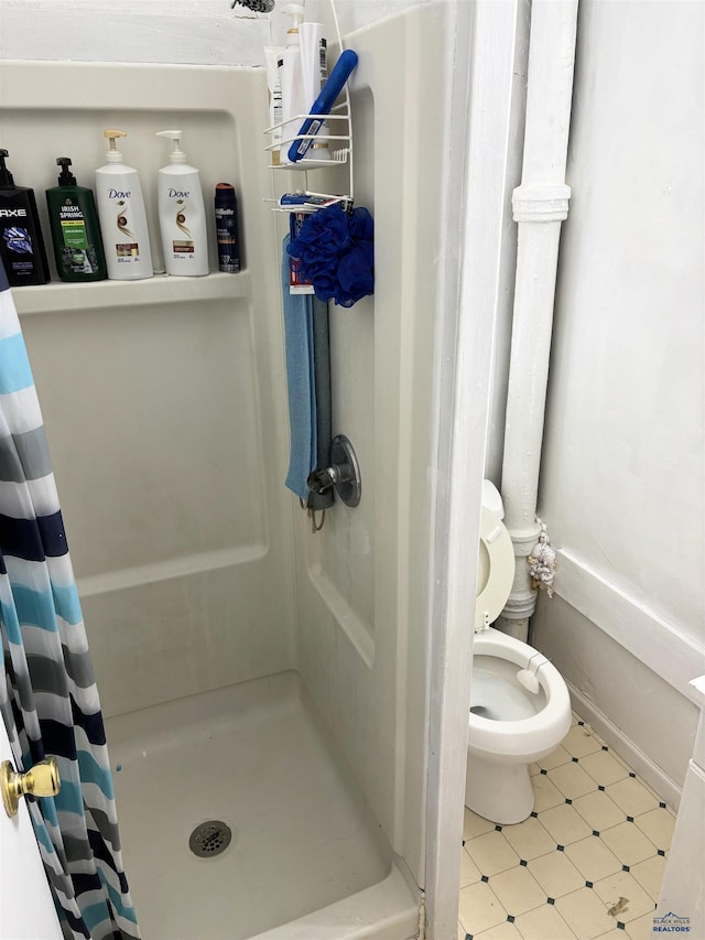 831 Dilger Ave, Rapid City, SD 57701 - bathroom with a stall shower, tile patterned floors, and toilet