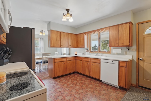 701 Hustead St, Wall, SD 57790 - kitchen with white appliances, a peninsula, a chandelier, light countertops, and a sink