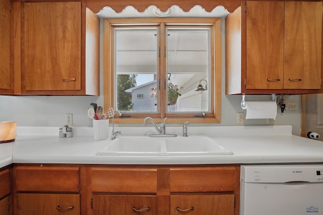 701 Hustead St, Wall, SD 57790 - kitchen featuring white dishwasher, a sink, light countertops, and brown cabinetry